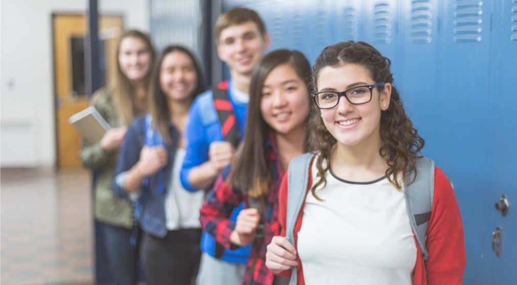 small-group-of-high-school-students-pose-in-the-hallway-picture-id952051748